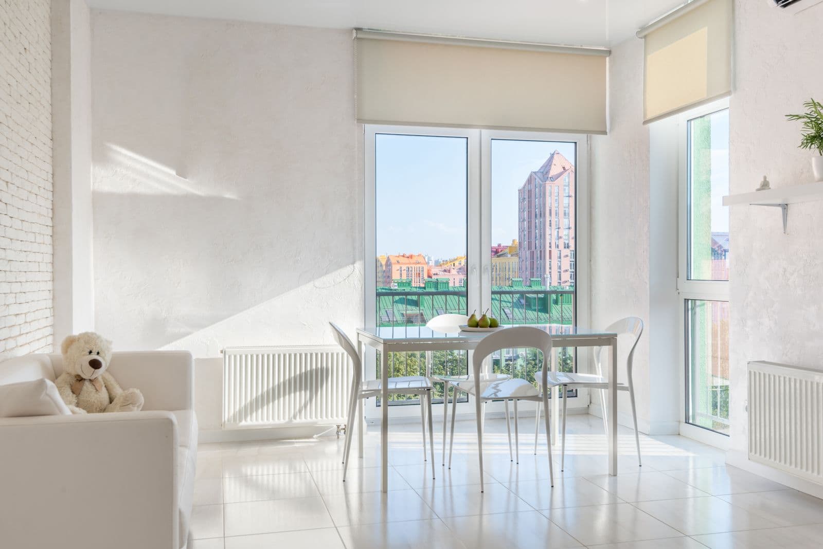 Balkon kapıları ve geniş pencerelerle aydınlanan bir yemek alanı